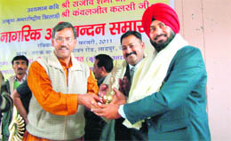 Agriculture Minister Trivendra Singh Rawat honours Sanjeev Sharma (middle ) and Kavaljeet Kalsi at a function at Raipur block, near Dehradun, on Sunday.