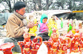Starting young: An artisan along with his child giving final touches to idols at Sanjauli near Shimla on Sunday.