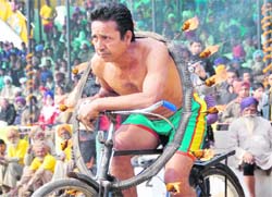 BURNING RIDE: Balbir Singh pedals with a burning tyre around his chest 