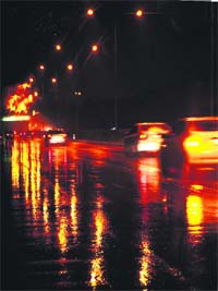 Reflection of lights on a road after rain lashed Chandigarh on Monday evening.