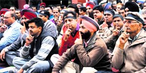 Finger on lips: Employees of the Chandigarh Housing Board stage a silent protest outside their office on Monday.