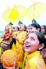Schoolgirls smile as they fly kites on the eve of Basant Panchami in Amritsar on Monday.