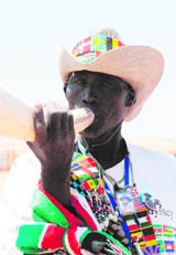 A South Sudanese man blows a horn to celebrate at the grave of former rebel leader and first president of the South John Garang in Juba on Monday
