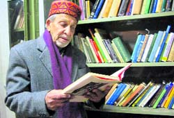 Kamal Prashad Sharma browses through a book in his library.