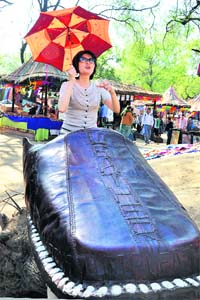 A foreigner sits inside a giant shoe during the Surajkund Crafts Mela in Faridabad