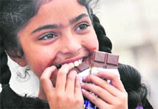 A girl enjoys a chocolate on Chocolate Day in Ludhiana on Wednesday.