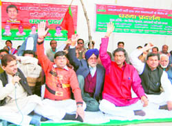 Samajwadi Party workers protest against inflation at the Gandhi Park in Dehradun on Thursday