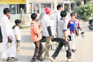 Children under 14 years of age on their way to earn livelihood in the name of Shani Dev in Karnal.