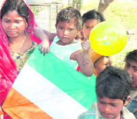 Children of slum-dwellers with kites and balloons gifted by students of the E-max Group of Institutes.