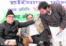 Finance Minister Ajay Singh Yadav blesses his son Chiranjeev, Haryana YC chief, at a function in Chandigarh on Thursday. 
