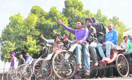  Students of Punjab Agricultural University pull rickshaws in Ludhiana on Thursday. 