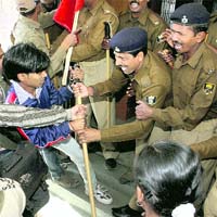 Policemen stop All-India Students Federation supporters during a protest against hike in examination fee in Patna on Thursday.