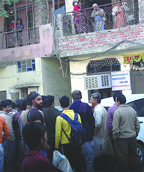 People gather at the spot of shooting at West Patel Nagar in New Delhi on Friday.