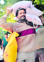 A man carries his quota of cheap ration in Dehradun on Friday