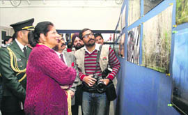 First Lady Usha Vohra has a close look at a photograph after inaugurating a photo exhibition by Jammu-based photojournalists at Kala Kendra in Jammu.