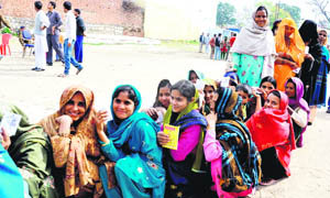 Women find time to rest while queuing up for voting at a polling centre at Bahadrabad in Haridwar district on Saturday.
