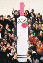 Students of a college hold a huge bat bearing their signatures and messages as they wish good luck to Team India for the Cricket World Cup, in Amritsar