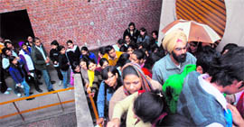 Panjab University students and passouts line up outside the universitys gymnasium hall to get their convocation robes on Sunday.