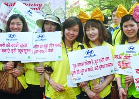 Korean volunteers hold placards during the Global Warming and Traffic Awareness campaign at Jantar Mantar in New Delhi