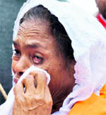 A Pakistani national wipes her tears as she watches the ashes being immersed in the holy Ganga.