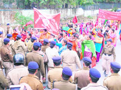 Anganwari workers being stopped by the police from moving towards the Chief Ministers residence during a protest in Dehradun on Sunday. 