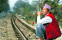 A man sits on the toy-train track along the National Highway 55 in Sukna village on the outskirts of Siliguri on Sunday