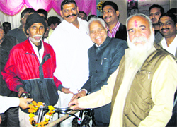 Minister Shiv Charan Lal Sharma gives away a bicycle to a labourer at a function in Bahadurgarh in Jhajjar 