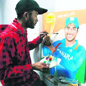 Jagjit Singh paints a portrait of Mahendra Singh Dhoni holding the Cricket World Cup in Amritsar