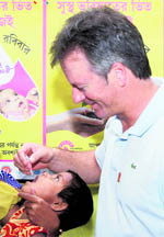 Former Australian captain Steve Waugh administers polio drops to a kid in Kolkata on Monday.