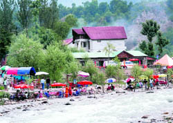 A resort swarming with tourists in Kullu along the Beas