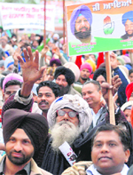 An elderly supporter holds a placard at the Congress rally in Ropar