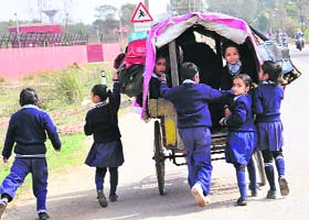 Students of Government School, Maloya village, head for home in a rickshaw on Wednesday