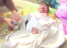 Gurdial, a patient, lies on the hospital lawns after he was allegedly shown the door by the hospital authorities in Fatehabad on Wednesday.