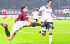 AC Milan forward Zlatan Ibrahimovic (left), challenges for the ball with Tottenham Hotspurs Sandro during their Champions League match in Milan