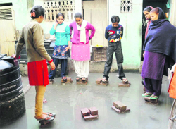 Family members of former IAF workman Dalpat Singh tread on bricks placed in the verandah of their house in Sirsa to save their feet from sewage