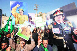 Supporters of Libyan leader Muammar Gaddafi hold his picture as they take part in a pro-government rally in Tripoli on Thursday