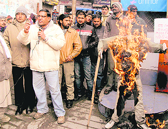 Members of the Bhavan Nirman Mazdoor Sangh burn an effigy of MDDA in Mussoorie on Friday.