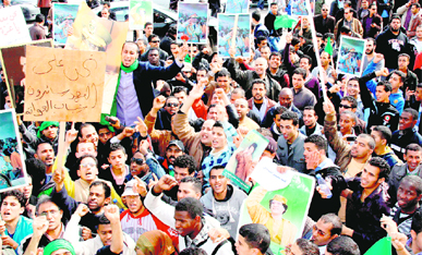 Libyan pro-government supporters hold portraits of Muammer Gaddafi during a gathering in Tripoli on Wednesday as Libya braced for a Day of Anger , following revolts in neighbouring Egypt and Tunisia. 