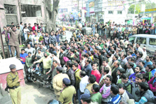 Shopkeepers gather at the Dhara police post to protest against the demolition of their shops near the Old Bus Stand in Dehradun on Saturday. 