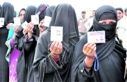 Women wait for their turn to cast their votes in the second phase of the panchayat elections at Narsain on Saturday
