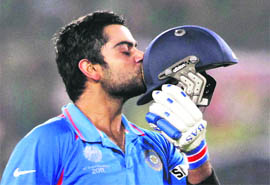 Virat Kohli kisses his helmet after completing his century during the Group B match against Bangladesh in Mirpur on Saturday.