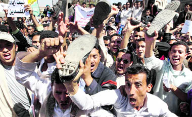 Anti-government protesters shout slogans as they raise their shoes during a demonstration in Sanaa on Saturday.