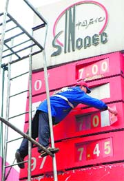 A worker changes the price signboards at a petrol station in Yichang, in central China's Hubei province on Sunday. China raised wholesale petrol and diesel prices by 350 yuan ($53) per tonne on Sunday, the second rise in two months in the world's second-largest fuel consuming nation, the government announced.