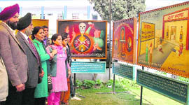 Visitors take a look at paintings during an exhibition at Guru Nanak Khalsa College in Ludhiana.