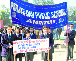 Students of Police DAV Public School carry a banner of their school, written in English, during the Vishal Punjabi Chetna March in Amritsar