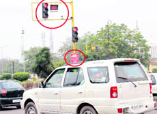 UNWATCHFUL EYE: A CCTV camera fails to act as a deterrent to violators as they can be seen jumping the red light at an intersection where cameras as well as a board with a warning have been installed.