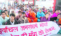 Members of the Poorvanchal Jansangharsh Morcha hold a demonstration at the Dehradun Railway Station 