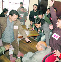 SFI activists argue with Naresh Mahajan, controller of examination, at Himachal Pradesh University in Shimla on Tuesday.