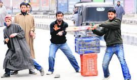 Youths play cricket on a deserted street during a bandh in Srinagar on Tuesday.