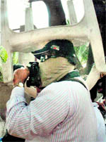 A cameraman protects himself during a clash at Osmania varsity.